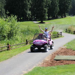Emily having fun driving the pink camouflage golf cart.